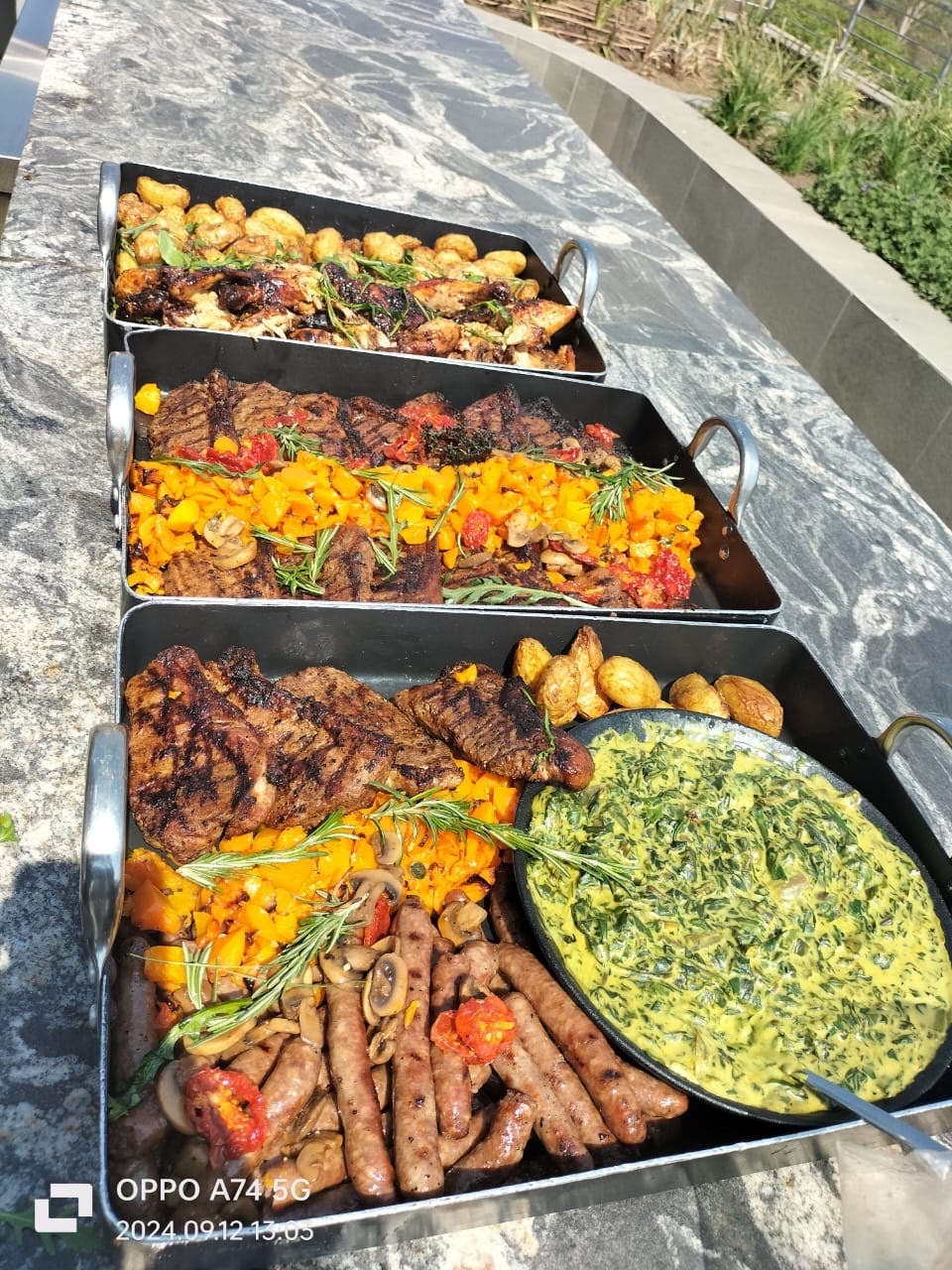 Outdoor braai spread with meats and creamed spinach